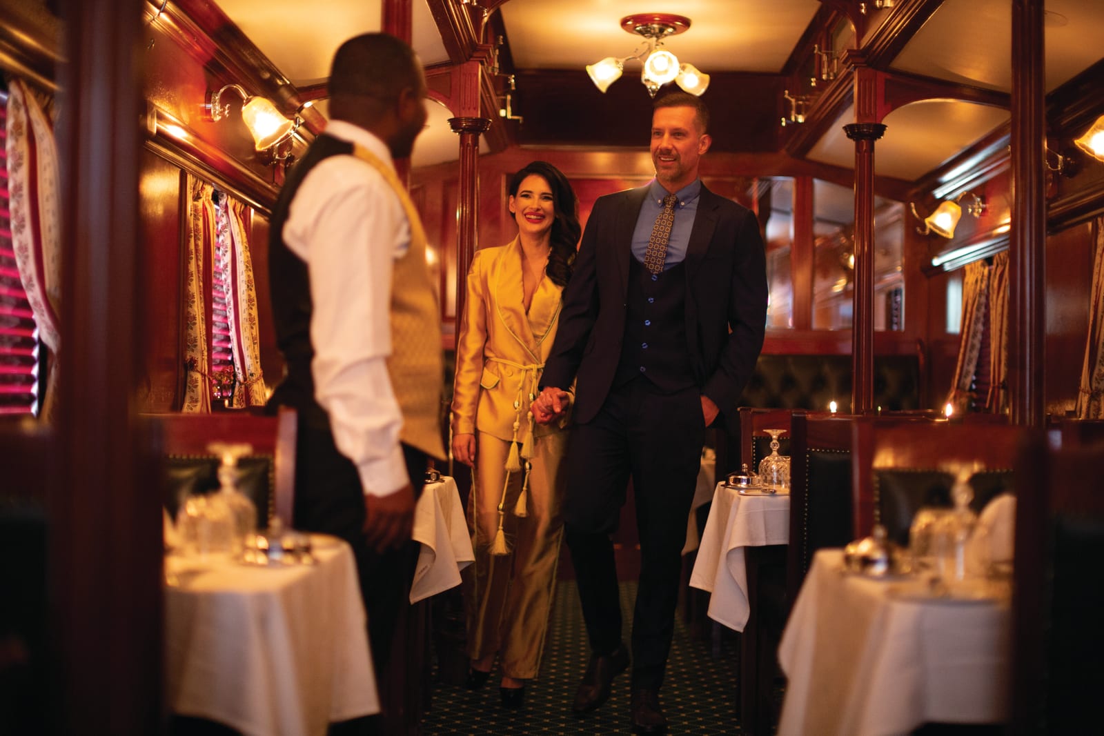 Guests entering a set dining car for dinner aboard Rovos Rail