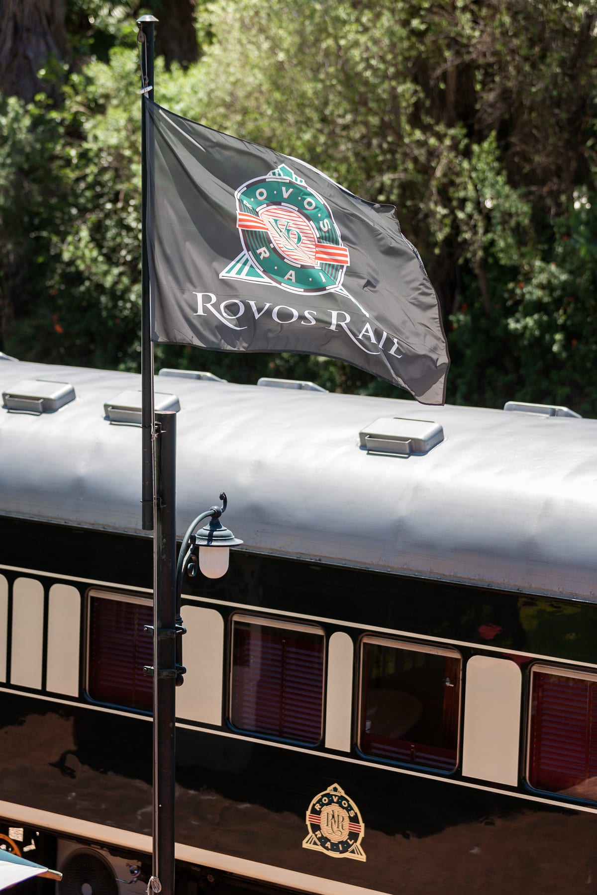 Rovos Rail flag flying above a cream-and-green passenger coach