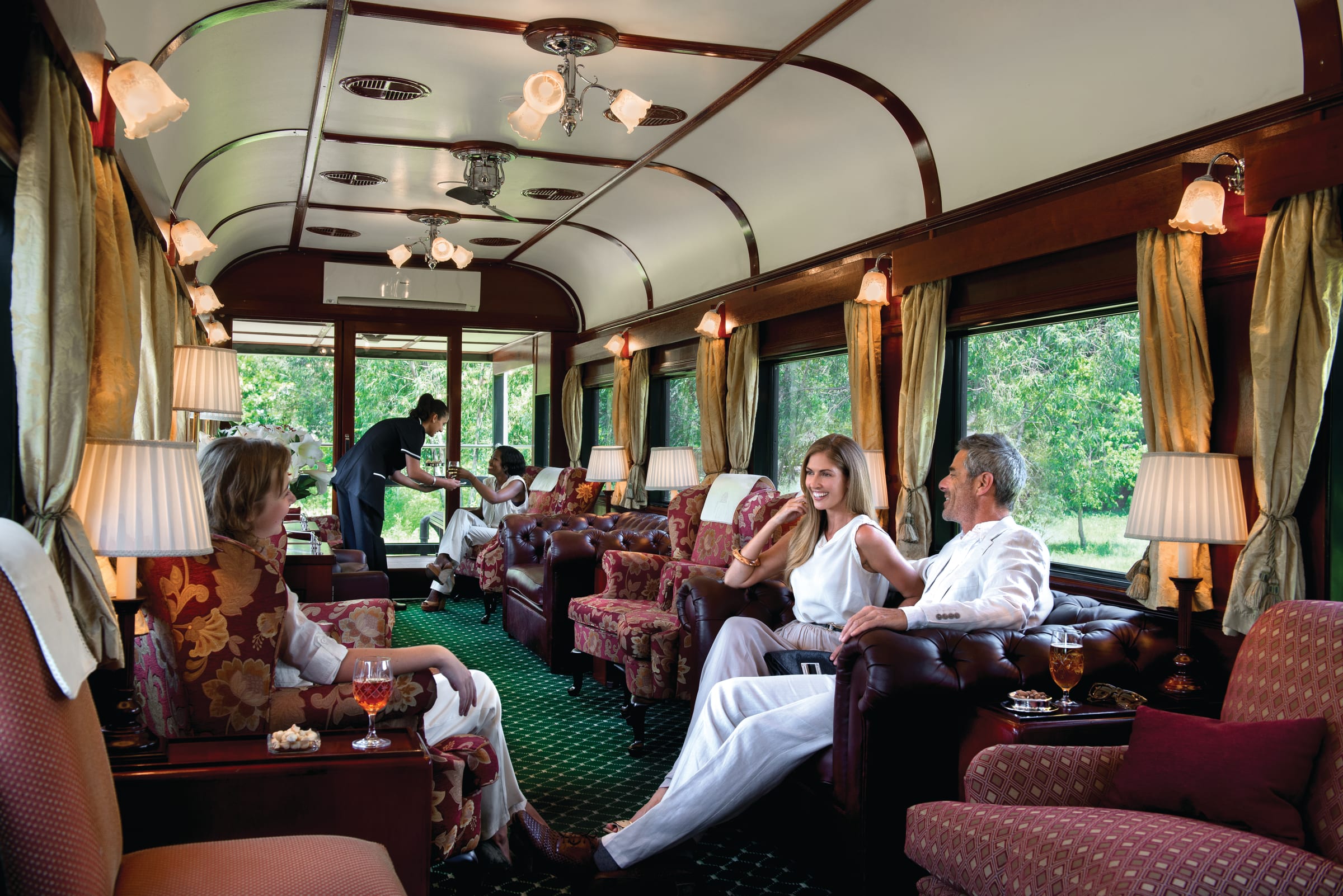 Guests seated in the wood-paneled observation car aboard Rovos Rail