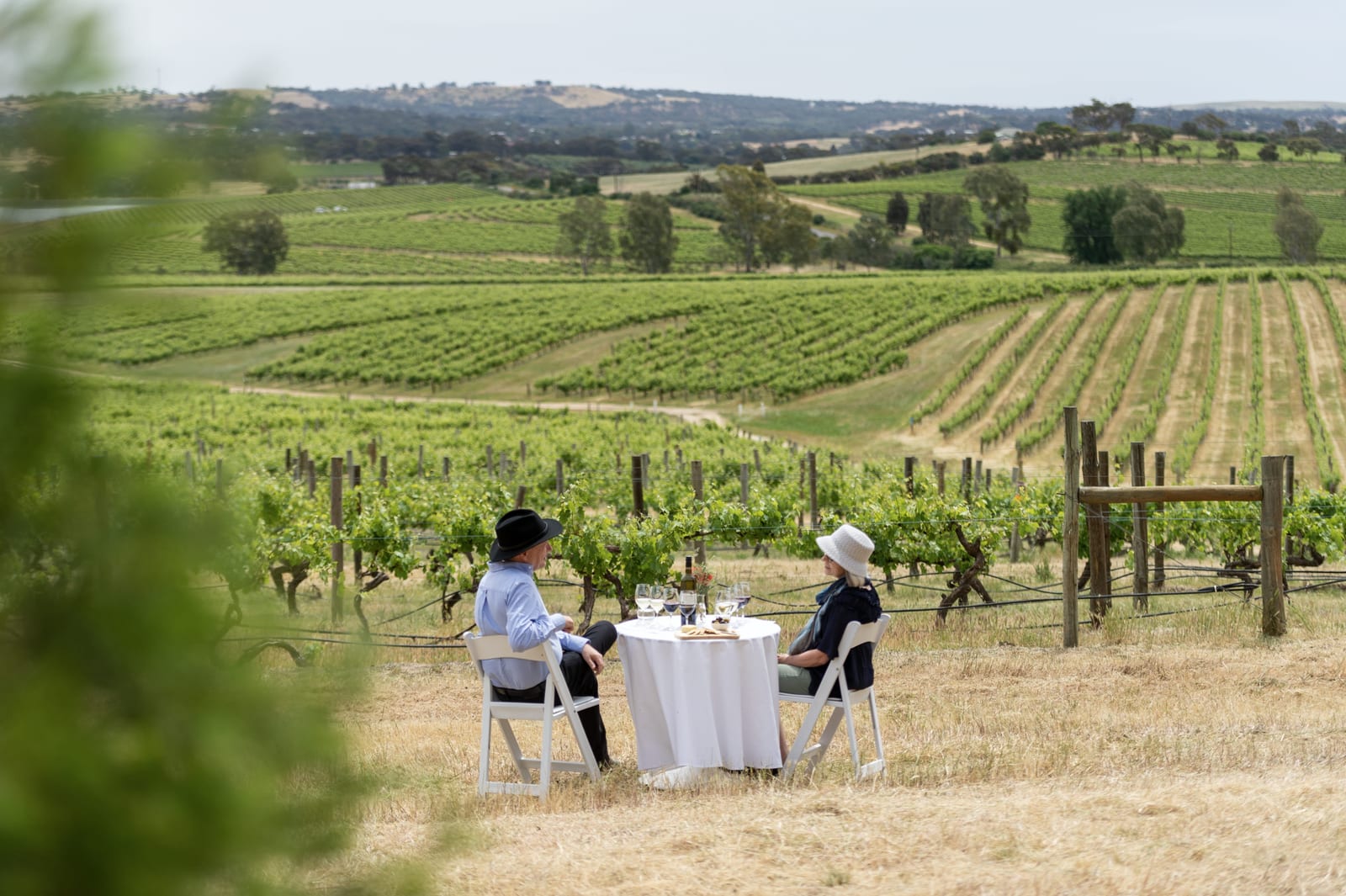 Couple seated at a table among Clare Valley vineyards in South Australia